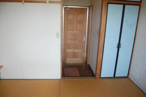 an empty room with a door and a room with a hallway at Minshuku Namisou in Iriomote