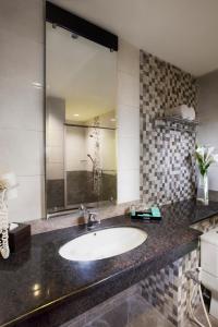 a bathroom with a sink and a large mirror at Regantris Malioboro in Yogyakarta