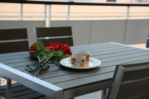 a table with a plate of roses and two cups at Suite Rosso & Nero in Lecce