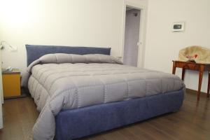 a large bed in a bedroom with a blue bed frame at Suite Rosso & Nero in Lecce