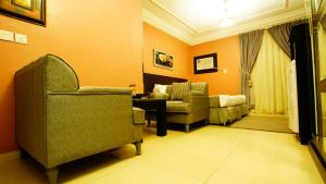 ein Wohnzimmer mit Stühlen, einem Tisch und einem Sofa in der Unterkunft Sama Al Qasr Al Muhammadiah in Riad