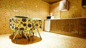 eine Küche mit einem Tisch und zwei Hockern in der Unterkunft Sama Al Qasr Al Muhammadiah in Riad