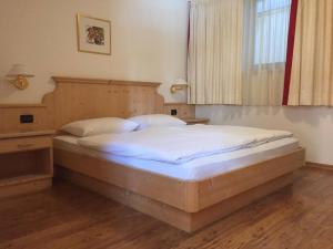 サン・カッシアーノにあるCiasa Fedoのベッドルーム1室(木製ヘッドボードと窓付)