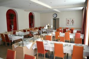 a dining room with tables and chairs and a clock at Hotel Grazerhof in Bad Gleichenberg