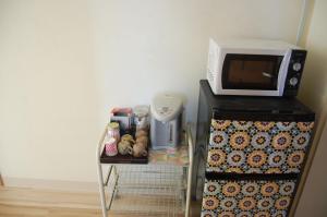a microwave oven sitting on top of a refrigerator at Minshuku Namisou in Iriomote