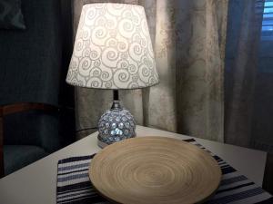 a lamp sitting on a table with a wooden plate on it at Kotimaailma Center 1 in Lahti