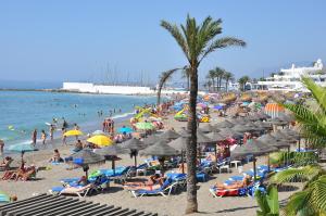 a beach filled with lots of umbrellas and people at Apartamentos Mediterraneo in Marbella
