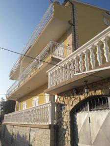 ein gelbes Gebäude mit weißen Balkonen darauf in der Unterkunft Apartmani Peran in Grebaštica