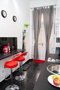 ブダペストにあるSomogyi Apartmanのキッチン(赤いバースツール、シンク付)