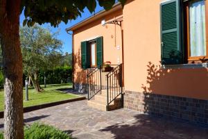 a house with green shutters and a staircase on it at I Sogni di Velia in Tuoro sul Trasimeno