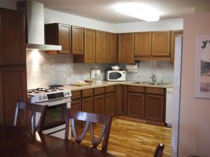 a kitchen with wooden cabinets and a stove top oven at Whale's Tail Guest Suites in Ucluelet
