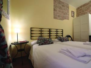 een slaapkamer met 2 bedden en een tafel met een lamp bij Residenza Raffaello in Foligno