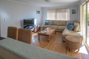 ein Wohnzimmer mit einem Sofa und einem Tisch in der Unterkunft Indoyo Retreat in Busselton