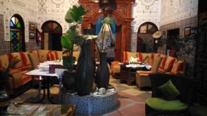 a restaurant with a table and chairs and a fountain at Ryad Bab Berdaine in Meknès