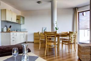kuchnia i jadalnia ze stołem i krzesłami w obiekcie Apartamenty Karin Wladyslawowo we Władysławowie