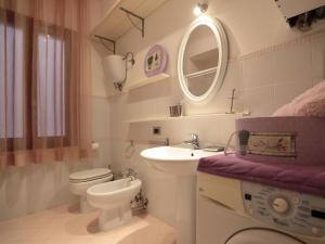 a bathroom with a sink and a toilet and a mirror at Residenza Raffaello in Foligno