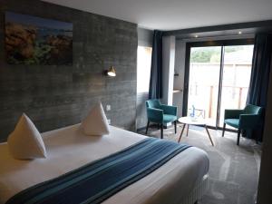 a hotel room with a bed and a table and chairs at Hôtel des Rochers in Perros-Guirec