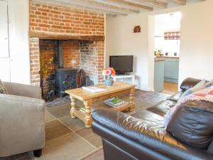 a living room with a couch and a fireplace at Thimble Cottage in Aldeburgh