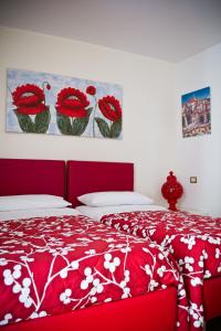 a bedroom with a red bed with red and white bedspread at san nicola d'amare in Bari