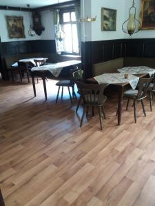 a dining room with wooden floors and tables and chairs at Steeger Weinstube in Bacharach