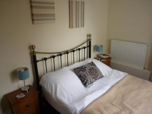 a bedroom with a bed with a pillow on it at Paragon Serviced Apartments in Cheltenham