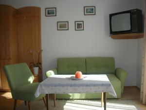 a living room with a couch and a table and a tv at Haus Ebner in Sankt Gilgen