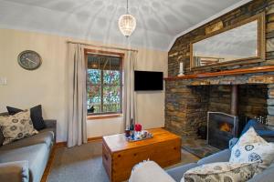 a living room with a couch and a fireplace at Stonewell Cottages and Vineyards in Tanunda