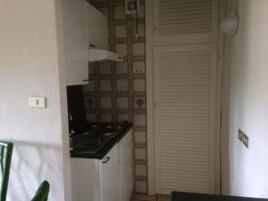 a kitchen with a sink next to a door at Appartamento in Rudargia Residence in Porto Rotondo