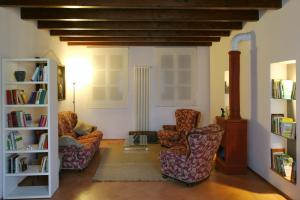 a living room with two chairs and a book shelf at Il Borghetto in Cavriago
