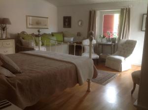 a bedroom with a bed and a table and chairs at Le petit Figuier in La Roque-dʼAnthéron