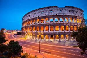 vista sul Colosseo di notte con una strada di fronte di Ines Downtown B&B a Roma