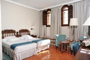 a hotel room with a bed and a table and chairs at Parador de Alcañiz in Alcañiz