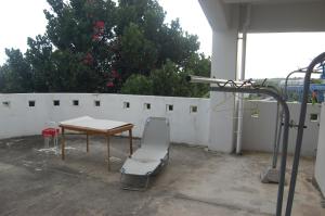 a table and a chair next to a white fence at Minshuku Namisou in Iriomote