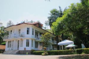 a white house with an umbrella in front of it at Musanto Hotel in Gisenyi