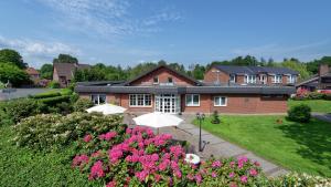 ein Haus mit zwei Sonnenschirmen davor in der Unterkunft Landhotel Zur Eiche in Buxtehude