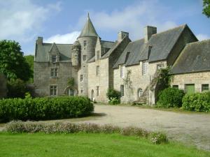 una vecchia casa in pietra con torrette di Manoir de Kerguéréon a Ploubezre