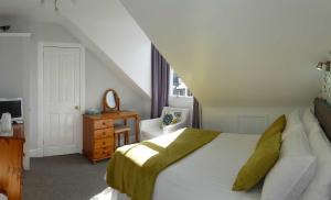 1 dormitorio con 1 cama, 1 silla y 1 ventana en Crioch Guest House, en Edimburgo