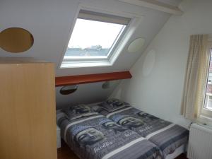 Bett in einem Zimmer mit Fenster in der Unterkunft Studio Zandvoort in Zandvoort