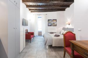 ローマにあるRoman Forum Suiteのベッドルーム1室(ベッド1台、赤い椅子2脚付)