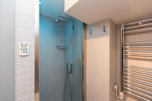 a bathroom with a shower with blue tiles at Roman Forum Suite in Rome +28 photos