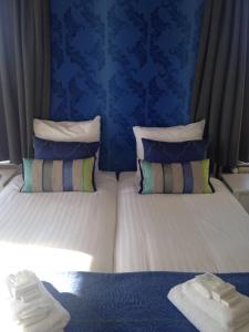 a bedroom with two beds with blue walls at Bed & Breakfast Geesberge in Maarssen