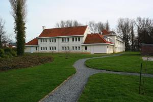 德哈恩Park Atlantis De Haan Klemskerke的白色的房子,有红色的屋顶和走道