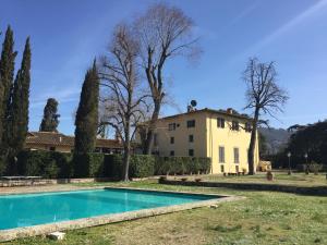 an estate with a swimming pool in front of a building at Villa Il Padule in Bagno a Ripoli
