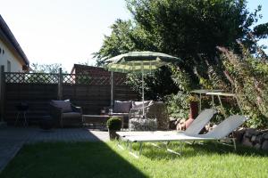 a person sitting in a lawn chair under an umbrella at Land & Meer in Hasselberg