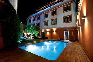 a swimming pool in front of a building at night at Hotel Infanta Leonor in Écija