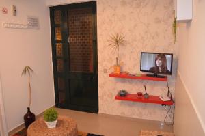 um quarto com uma televisão na parede em Apartamento Piquinho em Machico