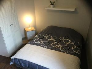 uma cama com uma almofada preta e branca num quarto em Résidence Champs Bouillant em Soissons