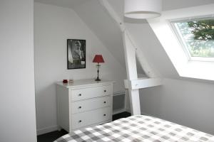 a bedroom with a bed with a dresser and a window at La Cattevillaise in Saint-Pair-sur-Mer