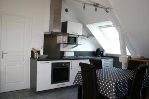 a kitchen with a sink and a stove top oven at La Cattevillaise in Saint-Pair-sur-Mer