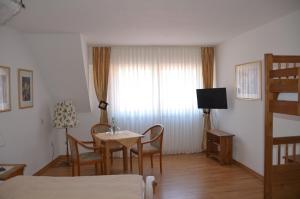 a room with a table and chairs and a bed at Hotel Feiden Garni in Ediger-Eller